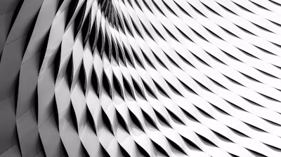 A curved facade covered in white latticework